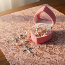 Load image into Gallery viewer, Pink heart shaped box with rosary beads on a pink lace tablecloth